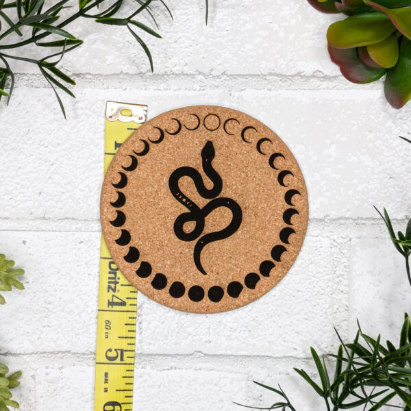 cork pad engraved with a snake and moons