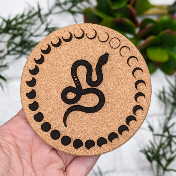 cork pad engraved with a snake and moons